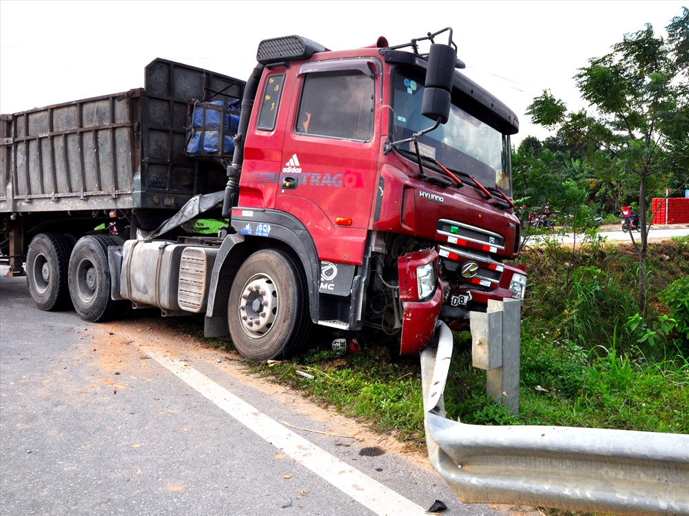 Chiếc xe máy nằm gọn dưới gầm xe,phần đầu xe dầu kéo bị biến dạng. Ảnh: PV