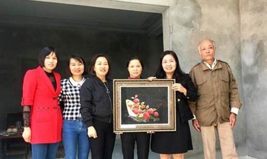 Gia đình chị Tạ Thị Định nhận quà tặng từ đại diện LĐLĐ huyện Hoài Đức. Ảnh: Nguồn LĐLĐ TP. Hà Nội