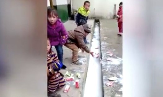 Hình ảnh trẻ đổ hàng loạt sữa học đường xuống rãnh nước. Ảnh: SCMP. 