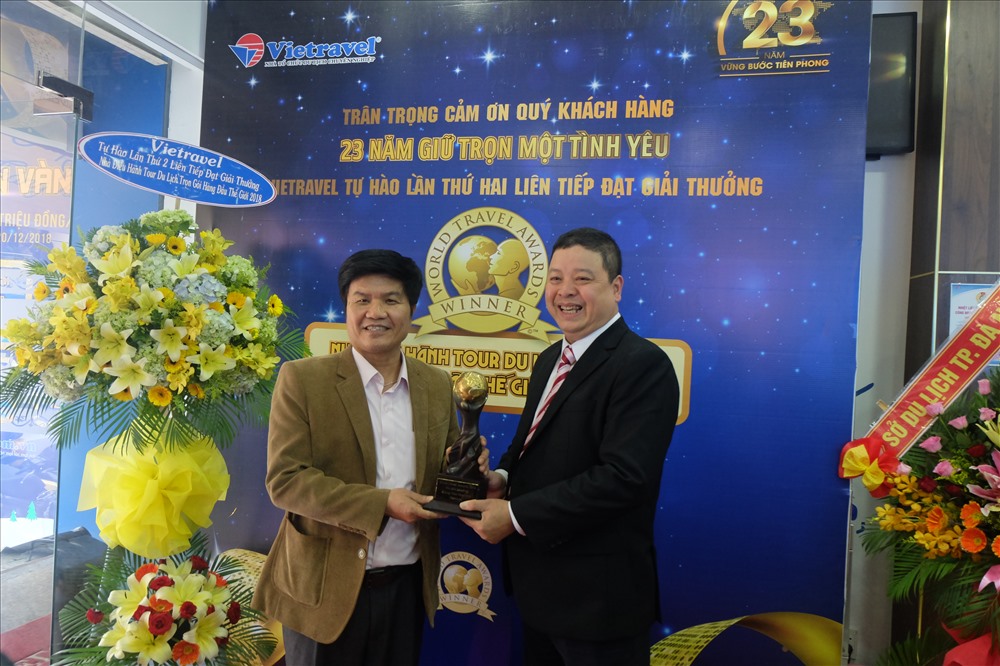 Ông Ngô Quang Vinh (bìa trái) - Giám đốc Sở Du lịch TP Đà Nẵng cùng ông Đoàn Hải Đăng (bìa phải) - Giám đốc Cty Du lịch Vietravel chi nhánh Đà Nẵng nâng cup World Travel Awards. 