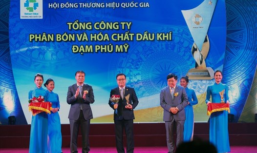 Phó Thủ tướng Trịnh Đình Dũng và Bộ trưởng Bộ Công Thương Trần Tuấn Anh chụp ảnh lưu niệm cùng đại diện các doanh nghiệp có sản phẩm được công nhận Thương hiệu Quốc gia năm 2018