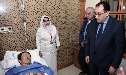 Thủ tướng Ai Cập Mostafa Madbouly thăm một người Việt bị thương trong bệnh viện. Ảnh: EFE