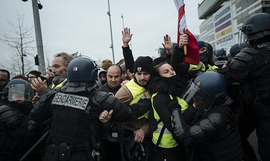 Các sĩ quan cảnh sát chống bạo động Pháp giữ lại những người biểu tình mặc vest vàng khi họ biểu tình trước mạng lưới truyền hình công cộng Pháp (France Tivi) tại Paris, Thứ Bảy, ngày 29 tháng 12 năm 2018. 