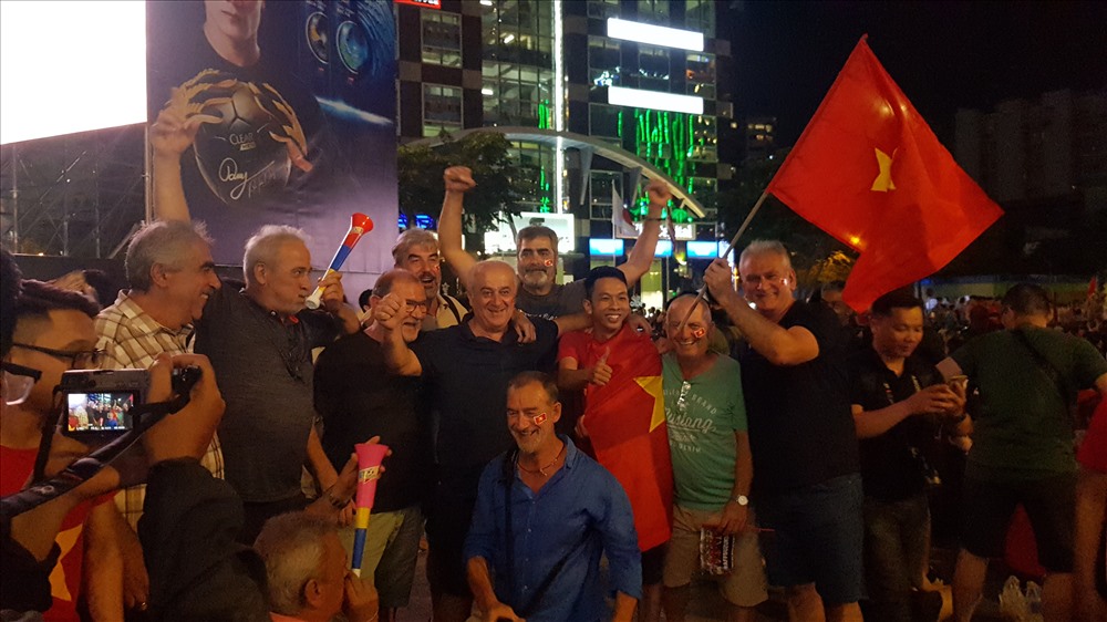 Nhóm cổ động viên nước ngoài đang đốt nóng không khí bóng đá trên phố đi bộ Nguyễn Huệ. Ảnh: Trường Sơn