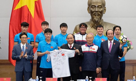 Thay mặt đội tuyển, HLV Park Hang-seo trao tặng Thủ tướng quả bóng vàng và chiếc áo có chữ kí của đội tuyển. Ảnh: Cổng thông tin điện tử Chính phủ.