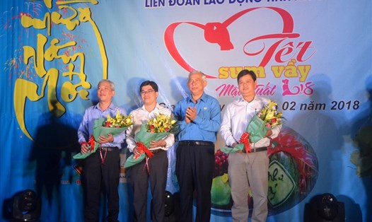 Ông Nguyễn Thiện Phú - Chủ tịch LĐLĐ An Giang- trao hoa biểu dương cho đại diện doanh nghiệp đã ủng hộ chương trình Tết sum vầy 2018. (Ảnh: Lục Tùng)