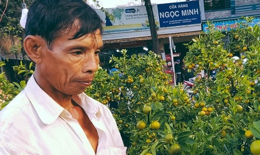 Ông Huỳnh Văn Vẹn (55 tuổi, quê Bến Tre), buồn bã vì hàng cây cảnh Tết ế ẩm. Ảnh: Kênh 14