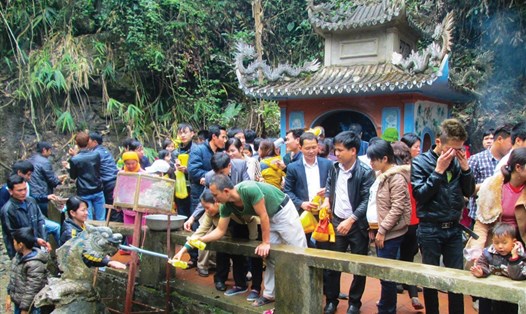 Mọi người chen nhau lấy nước Thánh ở phủ Na (xã Xuân Du) với mong muốn cầu cho các thành viên trong gia đình bình an, hạnh phúc. Ảnh: HT