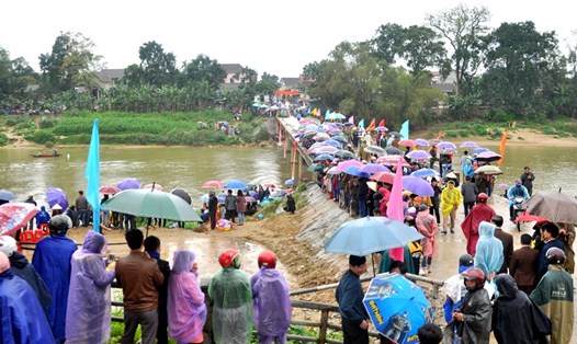 Hàng nghìn người dân đội mưa cổ vũ hội đua thuyền. Ảnh: Minh Lý