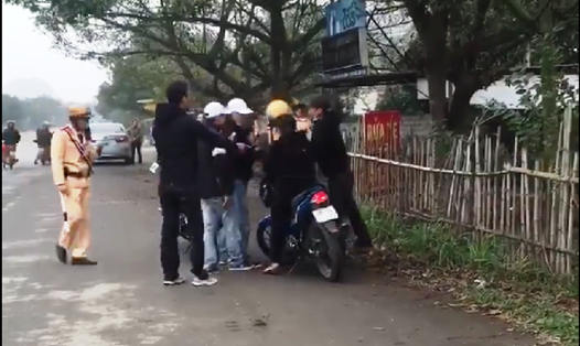 Sau khi bị lực lượng CSTG dừng xe, nhóm thanh niên đã quay lại vu khống CSGT đánh người để giải cứu cho chiếc xe bị bắt giữ. (Ảnh cắt từ Clip)