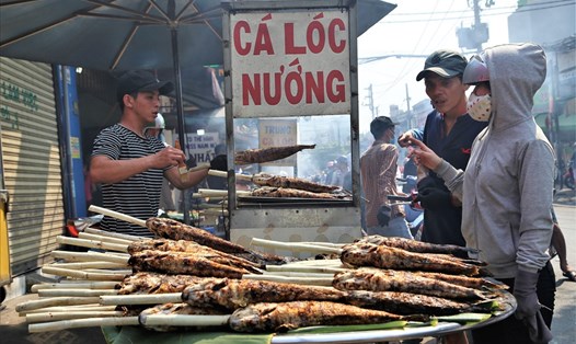 Người dân mua cá lóc nướng trên đường Tân Kỳ-Tân Quý về cúng ngày vía Thần Tài sáng nay. Ảnh: Trường Sơn