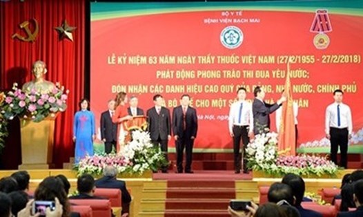 Chủ tịch Nước gắn Huân chương Lao động hạng Nhì lên lá cờ truyền thống của Bệnh viện Bạch Mai (Ảnh: VOV)