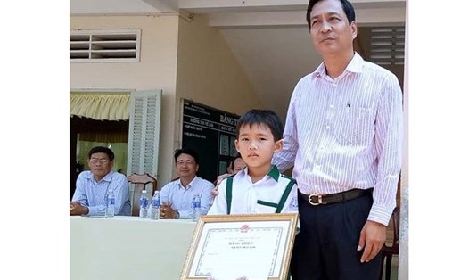 Phó Chủ tịch UBND tỉnh Cà Mau Trần Hồng Quân trao bằng khen cho em Nam.