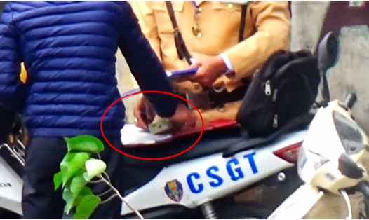 CSGT Hà Nội nhận một tờ nghi là tiền từ một người vi phạm giao thông - Ảnh cắt từ clip