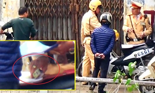 CSGT Hà Nội nhận vật nghi là tiền từ một người vi phạm giao thông. Ảnh cắt từ clip: VTC.