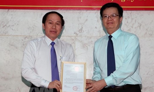 Ông Mai Văn Chính, Phó Trưởng ban Tổ chức Trung ương trao quyết định cho ông Lê Tiến Châu. (Ảnh: Duy Khương/TTXVN)