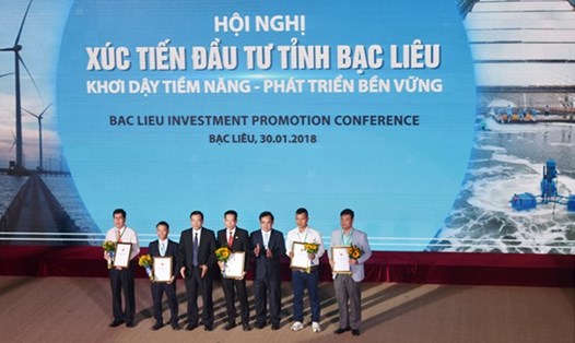 Chủ tịch UBND tỉnh Dương Thành Trung trao Giấy phép đầu tư cho các doanh nghiệp tại Hội nghị Xúc tiến đầu tư tỉnh Bạc Liêu năm 2018.