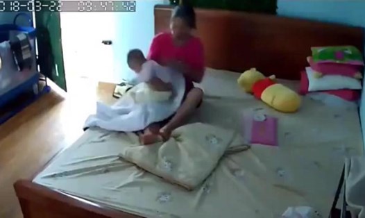 Hình ảnh người phụ nữ giật, lắc trẻ nhỏ cắt từ video được lan truyền trên mạng.