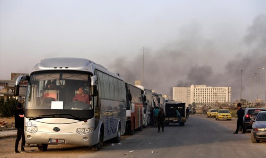 Hàng chục xe buýt chở các tay súng, người thân và dân thường rời Đông Ghouta từ hôm 22.3. Ảnh: Reuters. 
