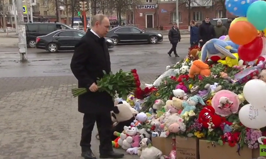 Tổng thống Vladimir Putin đặt hoa viếng các nạn nhân vụ hỏa hoạn. Ảnh: RT. 