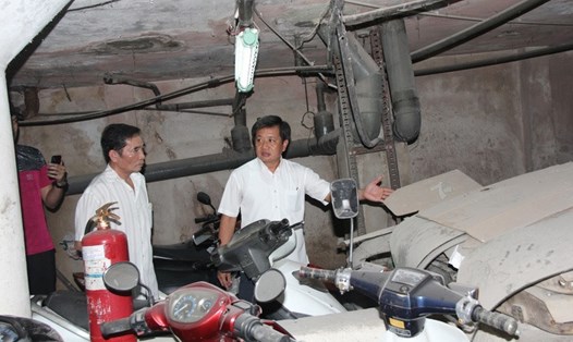 Ông Đoàn Ngọc Hải kiểm tra tầng hầm giữ xe chung cư 145 Nguyễn Trãi. Ảnh: QUANG KHẢI/Tuổi trẻ. 