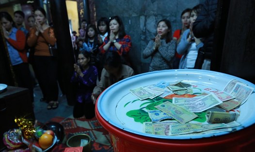 Du khách đi lễ đền bà Chúa Kho (Bắc Ninh) bỏ tiền giọt dầu khi làm lễ. Ảnh chụp chiều 2.3.2018. Ảnh: HẢI NGUYỄN