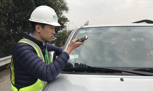 Nhân viên VETC dán tem thu giá tự động tại trạm lưu động ở cao tốc Hà Nội - Bắc Giang. Ảnh: K.H