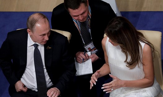 Tổng thống Vladimir Putin trò chuyện với đệ nhất phu nhân Mỹ Melania Trump. Ảnh: Reuters