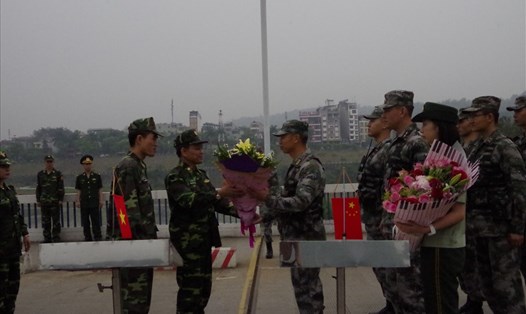 Chỉ huy trưởng Bộ đội biên phòng tỉnh Lào Cai Đại tá Đỗ Ngọc Tuấn (trái) tặng hoa cho Chỉ huy trưởng Bộ đội biên phòng Khu Mông Tự (Trung Quốc) Đại tá Dương Bân Bân.
