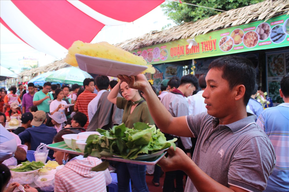 Một nhân viên đang đưa bánh phục vụ du khách thưởng thức ngay trước gian hàng tại Hội chợ. Ảnh: Trần Tuấn