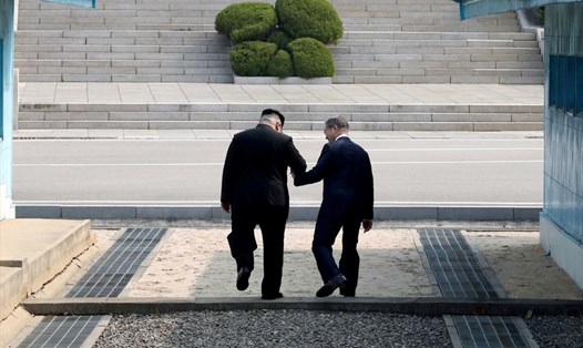 Tổng thống Hàn Quốc Moon Jae-in và nhà lãnh đạo Triều Tiên Kim Jong-un gặp nhau ở đường biên giới tại làng đình chiến Bàn Môn Điếm để bắt đầu hội nghị thượng đỉnh liên Triều hôm 27.4. Ảnh: Reuters