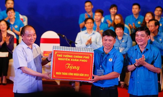 Thủ tướng Chính phủ Nguyễn Xuân Phúc và Chủ tịch TLĐLĐVN tặng bộ máy vi tính cho công nhân Vũ Xuân Đạt.