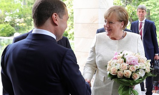 Tổng thống Nga Vladimir Putin tặng hoa Thủ tướng Đức. Ảnh: Tass. 