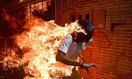 Bức ảnh Báo chí của năm: Người biểu tình Jose Victor Salazar Balza bốc cháy trong cuộc đụng độ với cảnh sát chống bạo động tại cuộc biểu tình chống lại Tổng thống Venezuela Nicolas Maduro, ở Caracas, Venezuela vào ngày 3.5.2017. Ảnh: Ronaldo Schemidt/AFP