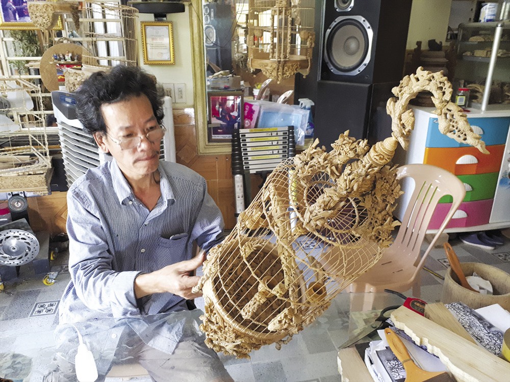 Ông Đoàn Minh Căn với chiếc lồng chim sắp hoàn thiện của mình. Ảnh: NĐT