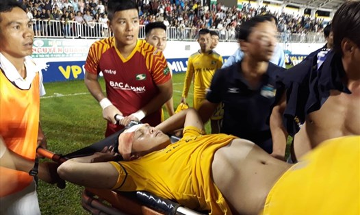 Hoàng Văn Khánh của SLNA đổ gục xuống sân sau trận đấu nhưng xe cứu thương đã di chuyển ra khỏi sân Pleiku. Ảnh: Đ.V