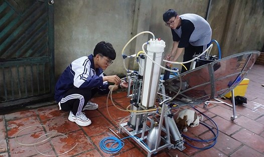 Em Nhật Anh (trái) và Văn Long đang kiểm tra dự án thiết bị "hô biến" nước mặn thành nước ngọt bằng năng lượng sóng biển. Ảnh: NA