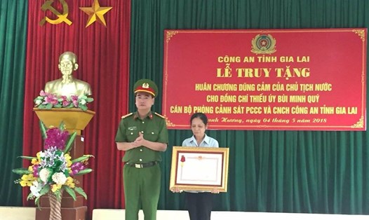 Người thân lên nhận phần thưởng cao quý mà nhà nước truy tặng thiếu úy Bùi Minh Qúy. ảnh: Quang Huy