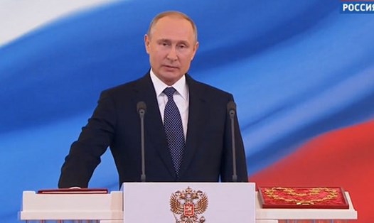Tổng thống Vladimir Putin đặt tay lên Hiến pháp Nga, đọc lời tuyên thệ nhậm chức. Ảnh: Rossiya 24