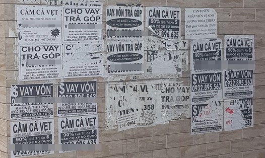 Một bức tường nhà dân trên đường Phùng Văn Cung, quận Phú Nhuận bị dán chi chít những mẩu tờ rơi quảng bá các dịch vụ cho vay tín chấp. Ảnh: T.S