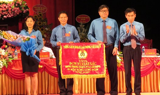 Phó Chủ tịch Tổng LĐLĐVN Trần Văn Thuật (ngoài cùng bên phải) tặng Cờ đơn vị xuất sắc trong phong trào CNVCLĐ và hoạt động CĐ năm 2017 cho LĐLĐ tỉnh Điện Biên. Ảnh: PV