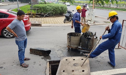 Công nhân Cty Thoát nước đô thị vớt lên một mảng xà bần lớn từ hệ thống cống dẫn nước về trạm bơm chống ngập cho đường Nguyễn Hữu Cảnh vào ngày hôm qua (2.6)
