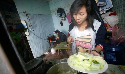 Nữ lao động nhập cư chuẩn bị bữa cơm trưa tại khu trọ tổ dân phố Kiên Thành, Trâu Quỳ, Gia Lâm (Hà Nội). Ảnh: Kỳ Anh