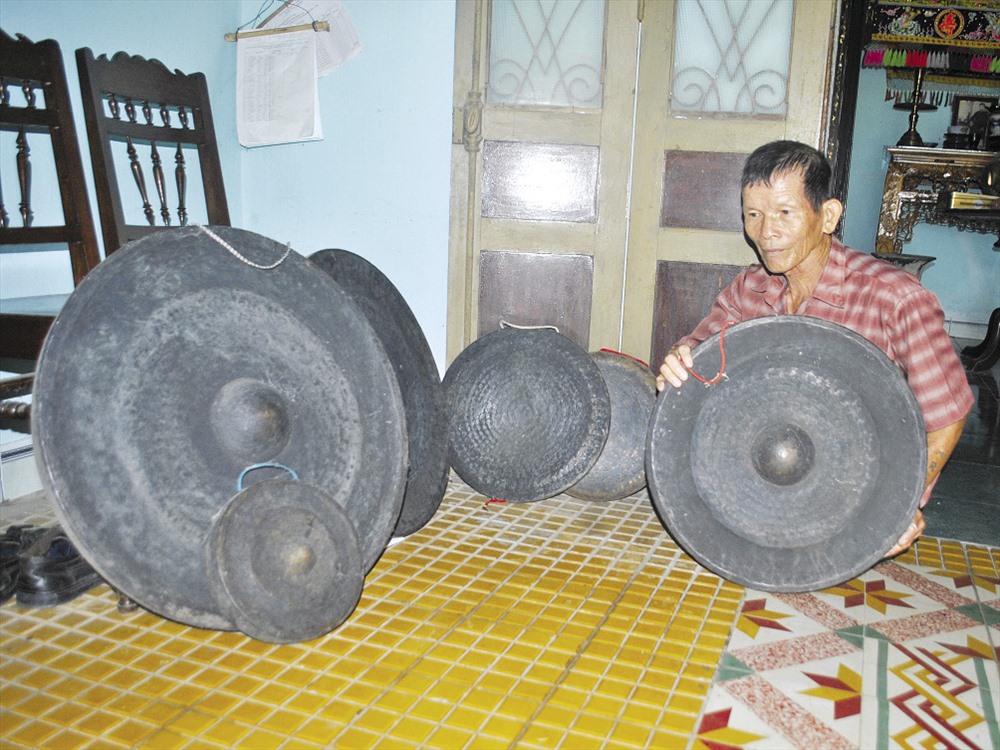 Ông Tại bên bộ cồng chiêng năm xưa còn giữ lại.