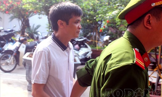 Cảnh sát dẫn giải ông Nguyễn Đình Lê (giáo viên Trường Tiểu học An Thượng A) ra tòa.