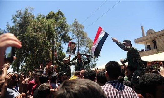 Người dân ăn mừng chiến thắng của quân đội Syria ở thị trấn Ibta, phía đông bắc Daraa ngày 29.6. Ảnh: SANA