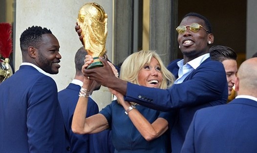 Pogba cùng Đệ nhất phu nhân Pháp nâng cao cúp vàng FIFA World Cup. Ảnh: Getty.