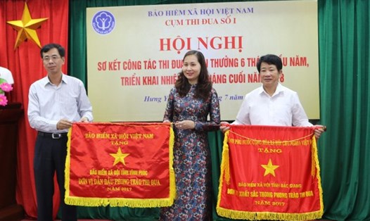 Phó Tổng Giám đốc BHXH Việt Nam Đào Việt Anh (bên trái ảnh) tặng cờ thi đua của Chính phủ và BHXH VN cho các đơn vị. Ảnh: H.Y