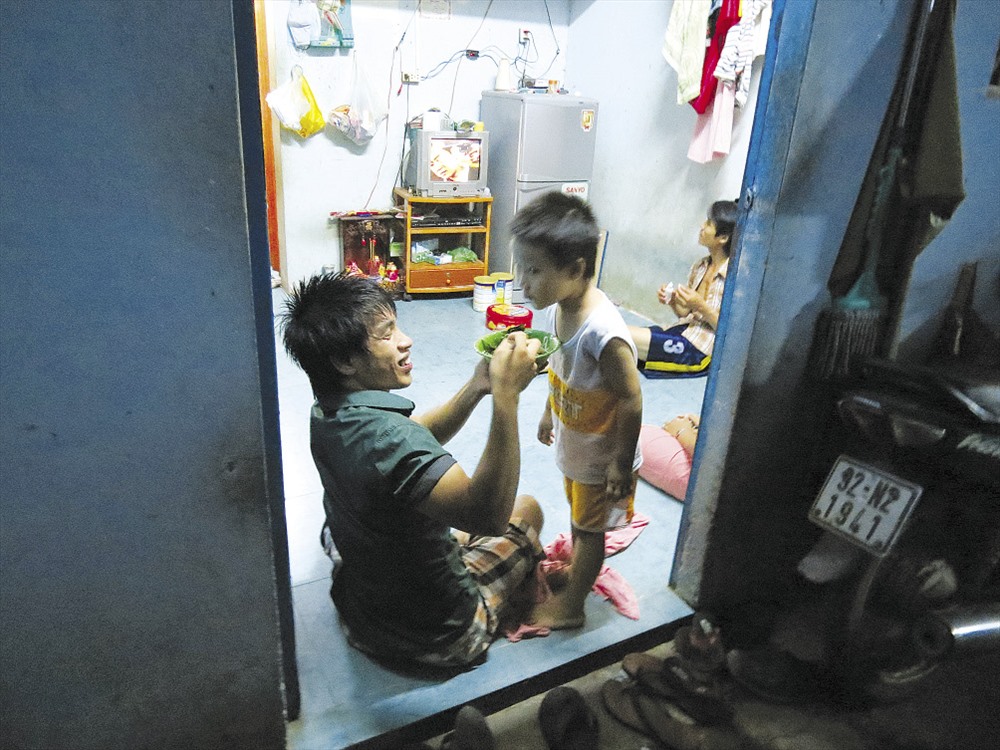 Phía sau người công nhân là gia đình - Ảnh: L.T