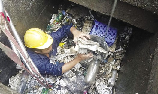 Công nhân vệ sinh ngâm mình trong cống vớt rác - Ảnh: MQ